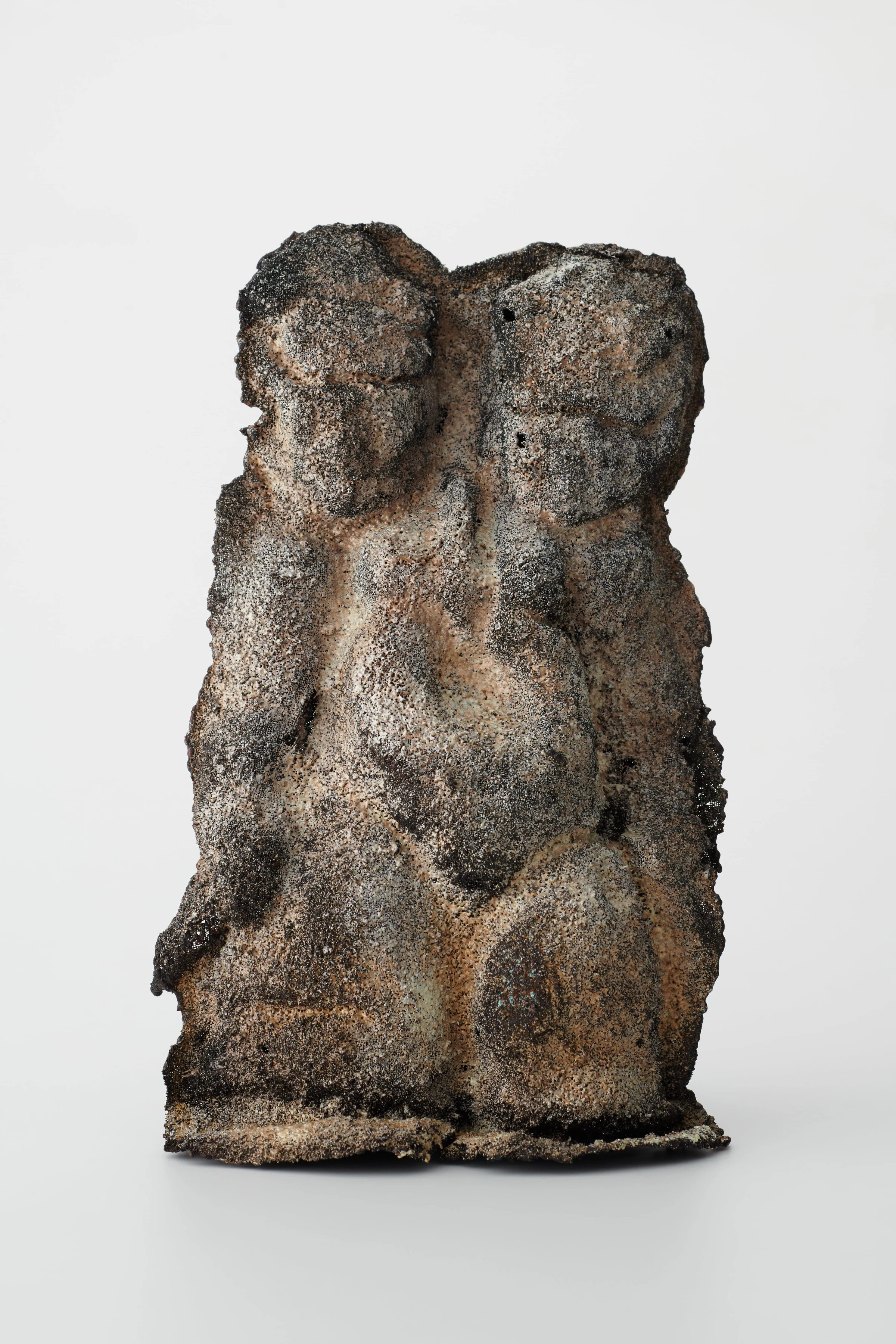 StoneSomira, a textured double-faced figure against a light background